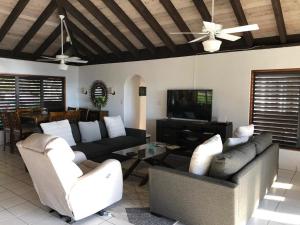 a living room with couches and a flat screen tv at VILLA VALMARC in Virgin Gorda