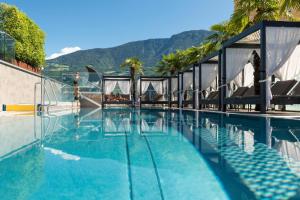 Ein Swimmingpool mit einem Berg im Hintergrund in der Unterkunft Hotel Ideal Park in Leifers