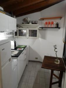 - une cuisine avec des appareils blancs et une table en bois dans l'établissement 2BCENTRAL, à Desenzano del Garda