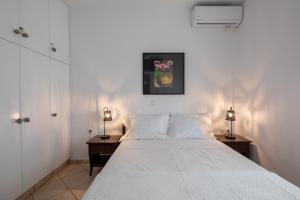 1 dormitorio con 1 cama blanca grande y 2 mesitas de noche en Drafies House en Mykonos