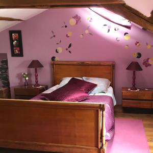 een slaapkamer met een bed met paarse muren bij Le Logis de la Pataudière in Champigny-sur-Veude