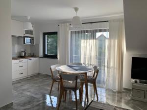 a kitchen and dining room with a table and chairs at Apartamenty Wydminy in Wydminy
