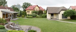 a backyard with chairs and a yard with houses at Garden Apartment in Cēsis