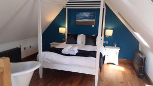 um quarto com uma cama de dossel e uma banheira em The New Inn em Cerne Abbas
