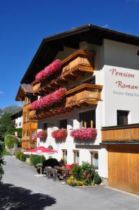 ein Gebäude mit Blumen auf der Seite in der Unterkunft Pension Roman in Pettneu am Arlberg