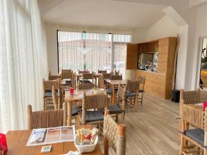 una sala da pranzo con tavolo e sedie di Hotel La Perla a Marina di Massa