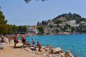 a group of people on a beach near the water at Apartman Laura in Tribunj