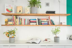 a white counter with two potted plants and books at Kolorowe Pola Boutique B&B in Polanica-Zdrój