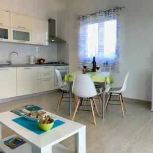 een keuken met een tafel en stoelen en een eetkamer bij Apartman Laura in Tribunj