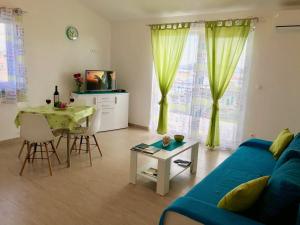 een woonkamer met een blauwe bank en een tafel bij Apartman Laura in Tribunj