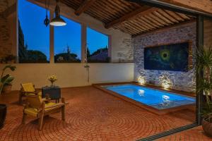 a swimming pool in a living room with a fireplace at La Remise Penthouse in Le Somail