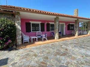 uma casa rosa com cadeiras e um pátio em CASA QUINTANA em Salamir