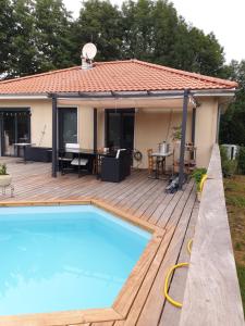 a house with a swimming pool on a wooden deck at Brigitte Carbonnel in Aydat