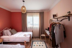 a bedroom with a bed and a desk and a window at Two Swings & A Pool - 5 min to Airport in Cairo