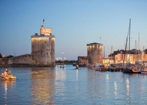 um grande castelo com barcos na água em Rue du port em La Rochelle