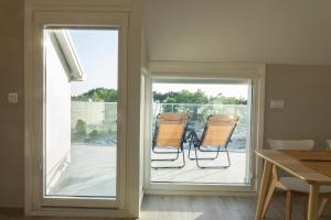 two chairs sitting on a porch next to a sliding glass door at Apartamentos Dunas de Samil in Vigo