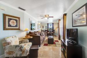 un soggiorno con un divano e una TV di Gulf View Cottage #3 a Bradenton Beach