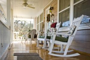 a porch with white rocking chairs and a window at Folkestone Inn in Bryson City +29 photos