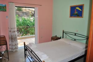 ツォウカラデスにあるMonika Lefkadaのベッドルーム1室(ベッド1台付)、窓、バルコニーが備わります。