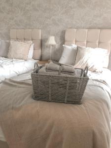 a bedroom with a bed with a basket on it at Boundary Cottage in Middleton