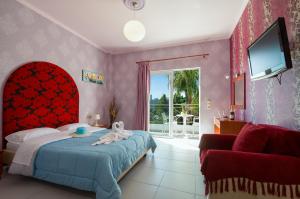 a bedroom with a bed and a tv and a couch at Paradice Hotel Luxury Suites-Near zorbas Beach-FREE Breakfast in Stavros