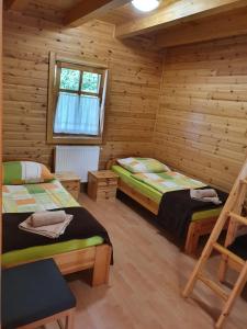 a bedroom with two beds in a log cabin at Bak Vendéglő faházak in Gyulakeszi