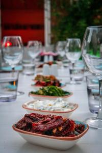 una mesa con platos de comida y copas de vino en Vintage Hotel Alacati en Alacati