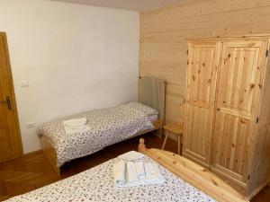 Habitación pequeña con 2 camas y armario en Casa Ortis, en Paluzza
