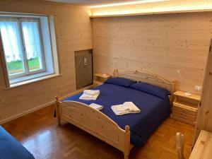 a bedroom with a bed with two towels on it at Casa Ortis in Paluzza