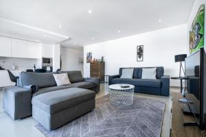 sala de estar con 2 sofás y TV en Private Condominium, Pool, Tennis & Sea View by Silver Prop, en Nazaré