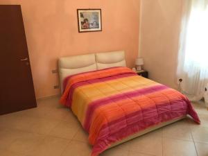 a bedroom with a bed with an orange and purple blanket at Lux Appartamento in Busso