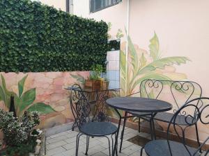 un patio avec deux tables et des chaises devant un mur dans l'établissement 2BCENTRAL, à Desenzano del Garda