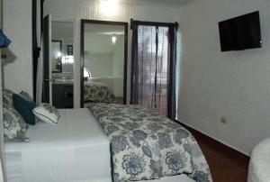 a hotel room with a bed and a television at Hotel Villas Las Anclas in Cozumel