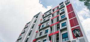 a tall building with red and white windows at AFP Residence Hotel in Bangkok