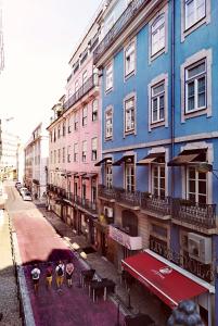 um grupo de pessoas andando por uma rua em frente aos edifícios em 262 Boutique Hotel em Lisboa