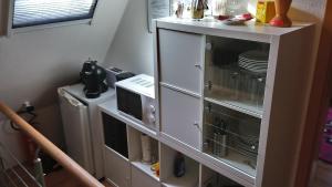 un armario blanco con platos en la cocina en Privates Einzelzimmer bei der Weser-Ems-Halle, en Oldenburg