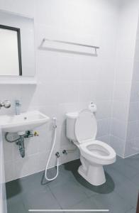 La salle de bains blanche est pourvue de toilettes et d'un lavabo. dans l'établissement AFP Residence Hotel, à Bangkok