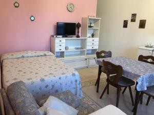 ガラトーネにあるCasa Christinaのベッドとテーブルとテレビのある寝室