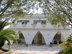 ガラトーネにあるCasa Christinaのアーチと木々のある大きな白い建物