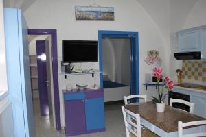 una cucina e una sala da pranzo con tavolo e TV di Casa Vacanza Arcobaleno a Oria