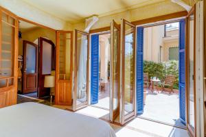 een slaapkamer met blauwe luiken op de ramen bij Villa Vallone Apartment in Bordighera