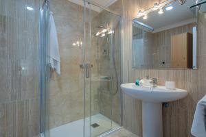 a bathroom with a glass shower and a sink at Deisy Apartments in Puerto de Mogán