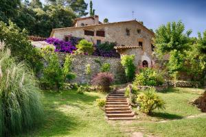 an old stone house with stairs in a garden at Masia Can Pou in Canet de Adri