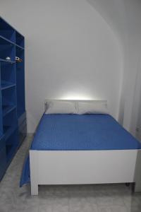 un letto in una camera con armadio blu di Casa Vacanza Arcobaleno a Oria