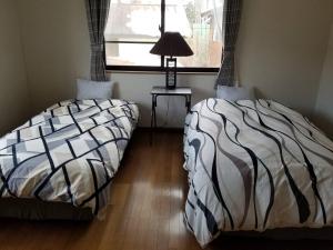 Duas camas sentadas uma ao lado da outra num quarto em C.T.Forest em Oshino