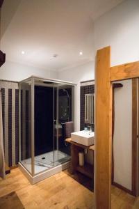 a bathroom with a glass shower and a sink at Modern & Recycled Guest House in Machico