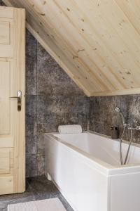 a bath tub in a bathroom with a wooden ceiling at Bukowy Raj in Wisła