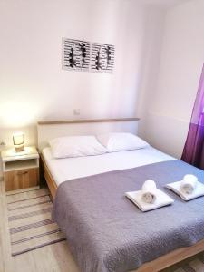 two beds in a small room with towels on them at Apartments Valiža 2 in Senj