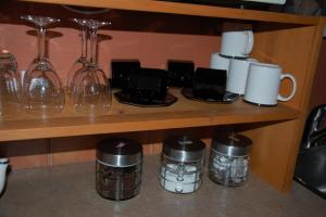 a shelf with wine glasses and coffee cups on it at A Vacation Paradise at Quail Ridge B&B in Kelowna