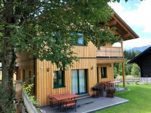 una casa con una terraza con mesas de picnic. en Ausseer Chalet (nahe Hallstatt), Appartements en Bad Aussee